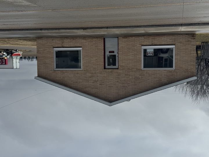 Front exterior of 116 W Broadway — brick veneer commercial office building