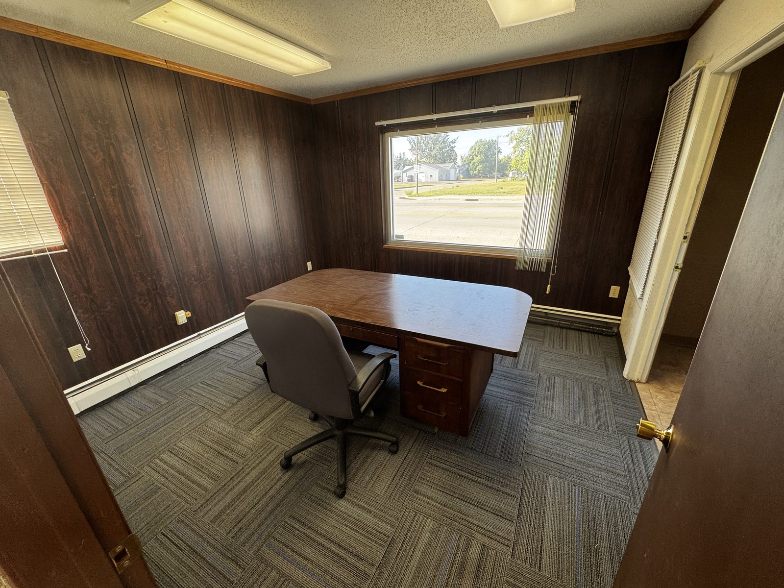 Wood-paneled office in Suite A with a large street-facing window